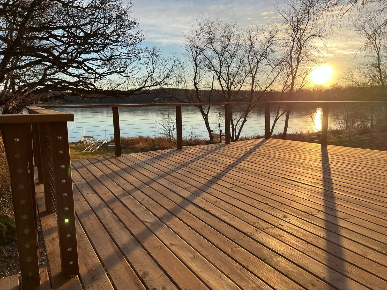 Wood deck overlooking a lake at sunset